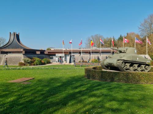 a statue of a tank in a field with flags at Les boréales in Bayeux