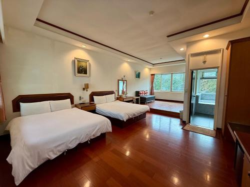 two beds in a room with wooden floors at 自在旅墅山莊 in Guoxing