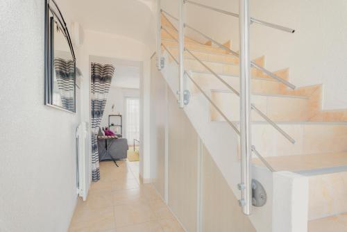 a hallway with wooden stairs in a house at Le Saint Martin Duplexe à la Mer in Bréhal