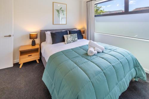 a bedroom with a bed with a teddy bear on it at Modern 4BR in Riccarton, Walk to Mall & Park in Christchurch