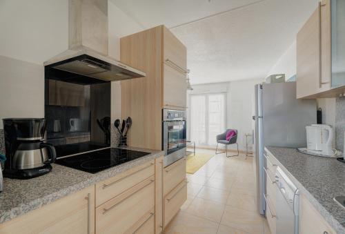 a kitchen with a stove and a refrigerator at Le Saint Martin Duplexe à la Mer in Bréhal