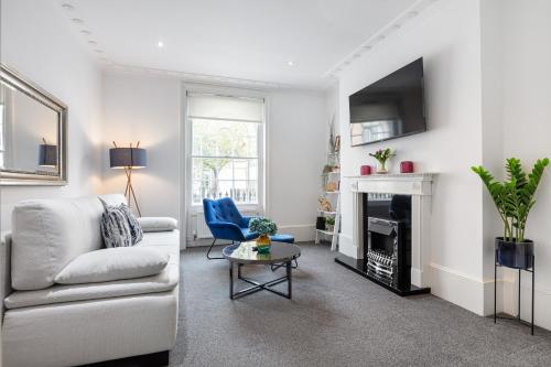 a living room with a couch and a fireplace at Stylish 2BR APT with Garden by St Pancras International in London