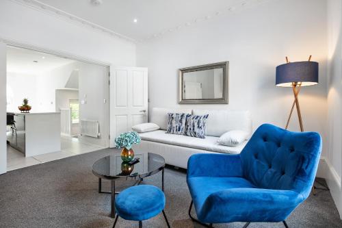 a living room with a blue chair and a couch at Stylish 2BR APT with Garden by St Pancras International in London