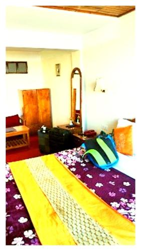 a bedroom with a bed and a table and a mirror at Hotal North 4 Star darjeeling in Darjeeling