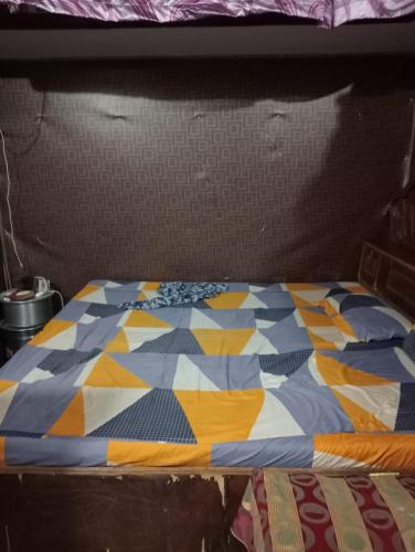 a bed with a colorful quilt on top of it at Shaida Homestay in Dāsna