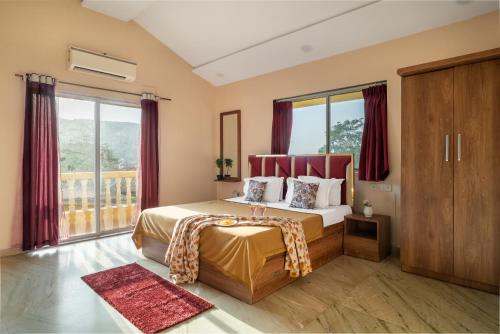 a bedroom with a large bed with red curtains at Newly Renovated-Farm Villa -6BHK with Pool & Turf in Lonavala