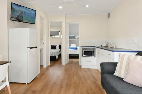 a kitchen and a living room with a couch and a kitchen at Flynns Beach Caravan Park in Port Macquarie