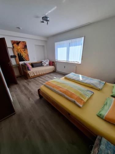 a bedroom with two beds and a couch at Haus am Dreifelder Weiher in Dreifelden