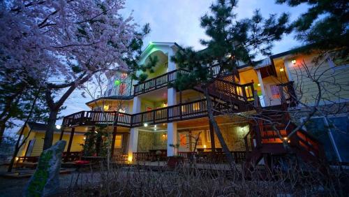 a large house with a staircase in front of it at Buan bada yeohang pension in Buan