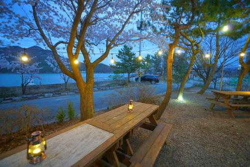 a wooden picnic table with a bottle of beer on it at Buan bada yeohang pension in Buan
