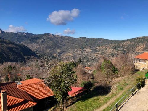 a view of a hill with houses and mountains at Helmos View - Relaxation & Nature in Valimí