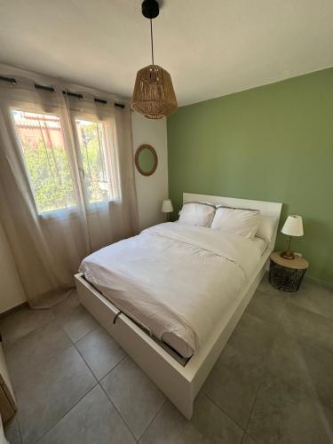 a bedroom with a large white bed with two windows at Cala Serena Saint Cyprien in Lecci