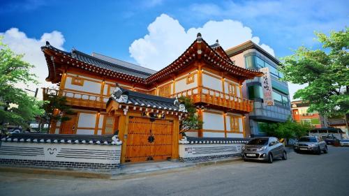 a wooden building with a car parked in front of it at gongju dalbicjeongweon hanog pensyeon in Kwan-gol