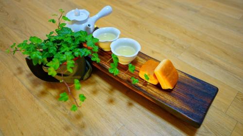 a tray with cups and a plant on a table at gongju dalbicjeongweon hanog pensyeon in Kwan-gol
