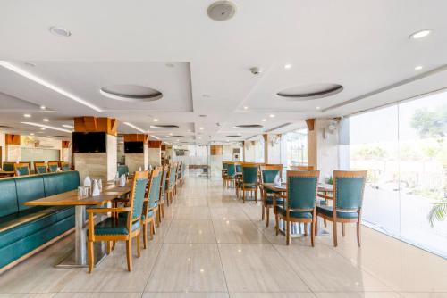 a dining room with chairs and tables in a restaurant at Treebo Premium Vinnie - Near Airport in Jaipur