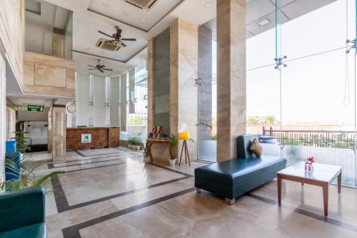 a living room with a couch and a table at Treebo Premium Vinnie - Near Airport in Jaipur