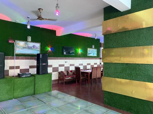 博瓦利Sitara Ambience Resort Halwani-Kaichi dham Bypass Road的一间设有桌子和绿色墙壁的用餐室