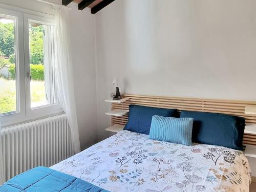 a bedroom with a bed with blue pillows and a window at Casa La Pace in Barga