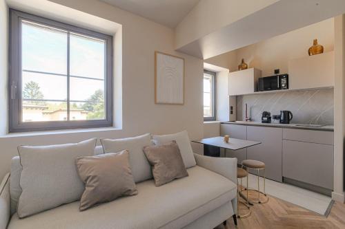 a living room with a couch and a kitchen at Havre de paix à proximité de Lyon in Écully