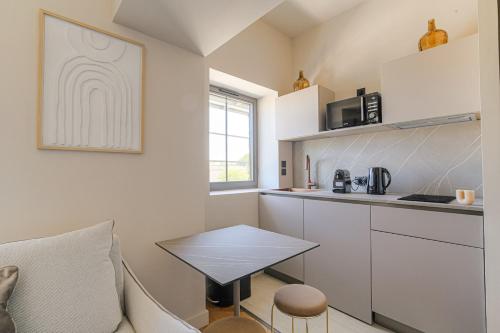 a small kitchen with a table in a room at Havre de paix à proximité de Lyon in Écully