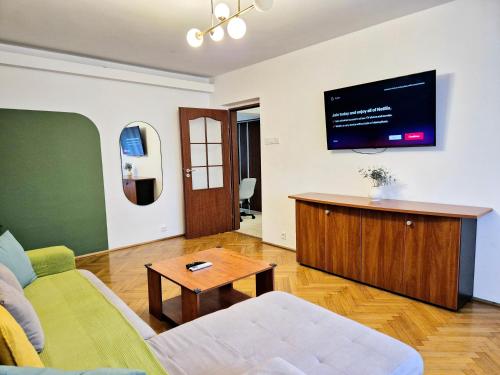 a living room with a couch and a tv on the wall at TRANQUIL Unirii - Airy & Comfy with Parking - Next 2Parliament in Bucharest