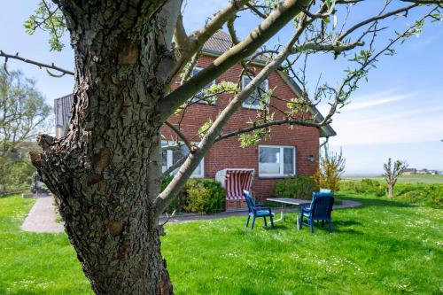 a house with two chairs and a table in the yard at Gästehaus Tadenswarf in Tadenswarf