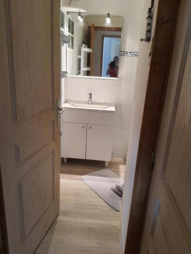 une salle de bain avec un lavabo et un miroir dans l'établissement L'escapade, à Carolles