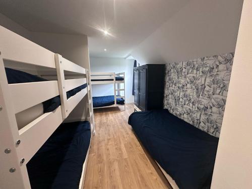 Cette petite chambre comprend des lits superposés et un lit. dans l'établissement Villa de TYN boucle de la Seine, à Caumont