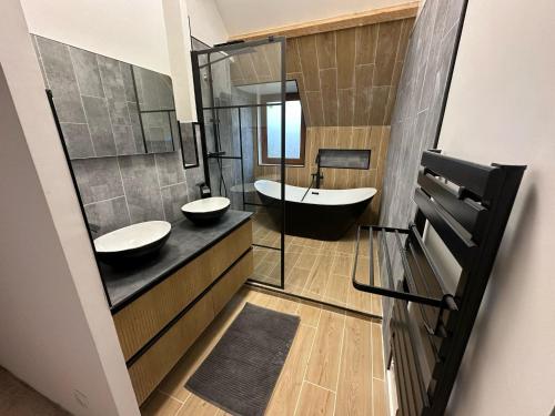 une salle de bain avec deux lavabos et une baignoire dans l'établissement Villa de TYN boucle de la Seine, à Caumont