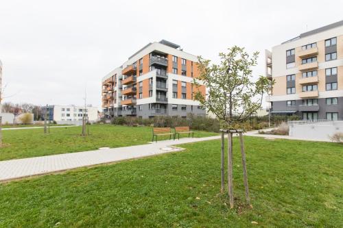 a tree in a park next to a building at Brand-new, equipped studio near the metro in Prague