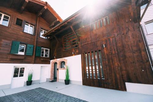 a wooden building with a large wooden door at Lakeside Barn Apartment near Interlaken in Bönigen