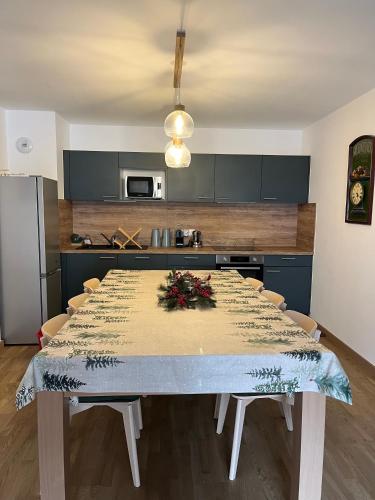 - une cuisine avec une grande table et des fleurs dans l'établissement Midori T3 77 m2, à Vars