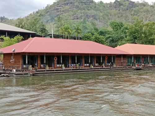 a building with a red roof next to a river at มาตาบุรี ริเวอร์เเควรีสอร์ท in Ban Gaeng Cho