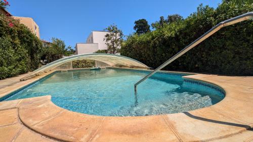 une piscine avec un tuyau métallique dans une cour dans l'établissement Grande Maison avec piscine, parking et wifi, à Balaruc-les-Bains
