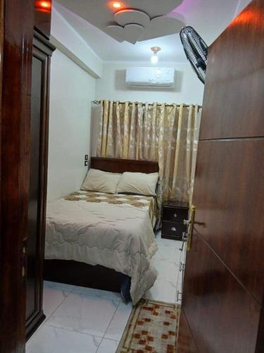 a small bedroom with a bed and a window at Al Fahad building in Luxor