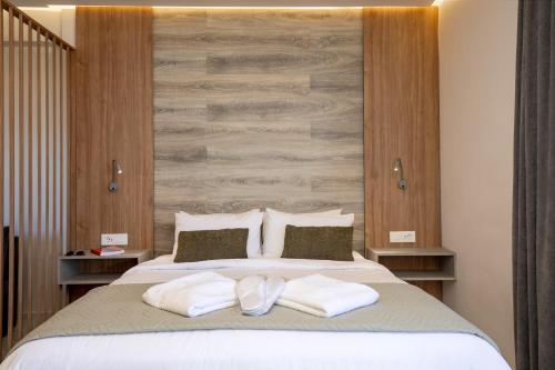 a bedroom with a large bed with two white towels at Anele Luxury Suites - Roof Top Jacuzzi in Chania Town