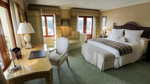 a hotel room with a bed and a chair and a desk at Delamar Greenwich Harbor in Greenwich