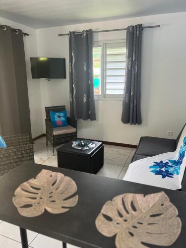 a living room with a couch and a table at Fare Heana- Beau bungalow Moorea in Moorea
