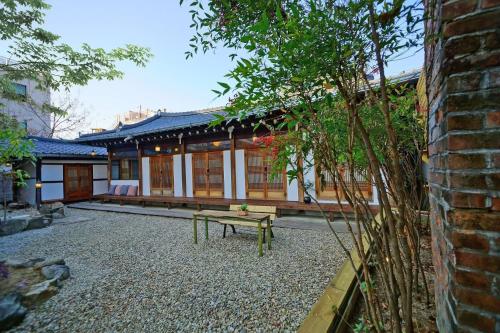 Un edificio con un banco delante de él. en Hanok Mibbeum, en Jeonju