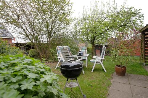 a grill in a garden with chairs and a table at Ferienwohnung Bunsoh in Bunsoh