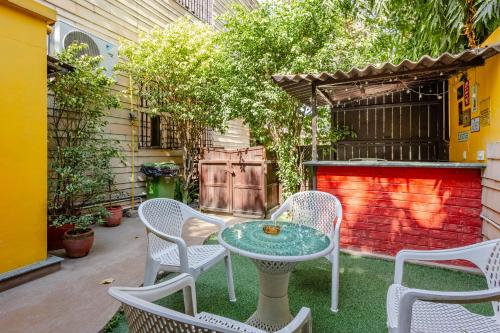 a patio with a table and chairs and a fence at Cp Villa - Rooms with Patio in New Delhi