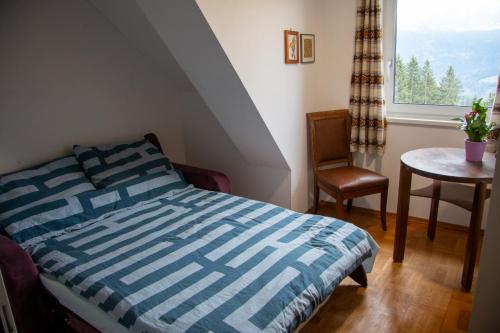 a bedroom with a bed and a table and a window at Urlaub wie früher bei Oma in Hermagor