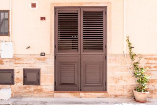 a large wooden door on a building with a plant at Cantina Rustica in Montallegro