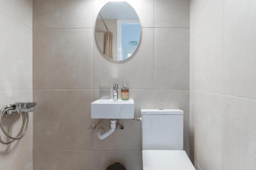 a bathroom with a white toilet and a mirror at Stenies Little Nook in Steniaí