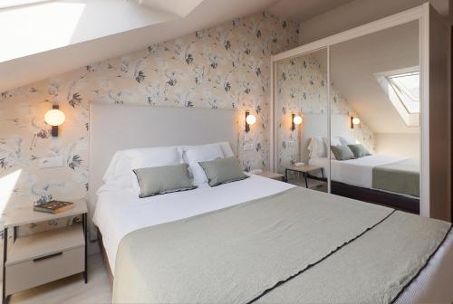 a bedroom with a large white bed and floral wallpaper at Hotel Ribadesella Playa in Ribadesella