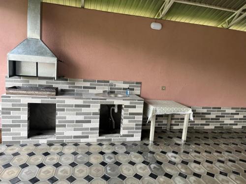 a kitchen with a brick fireplace and a chair at Gabala Home in Gabala