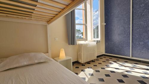 ein Schlafzimmer mit einem Bett und einem großen Fenster in der Unterkunft Grande Maison avec piscine, parking et wifi in Balaruc-les-Bains
