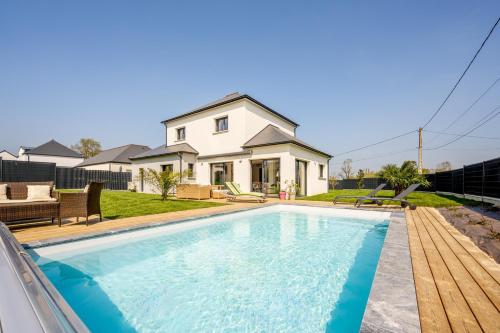 une piscine devant une maison dans l'établissement Villa du Clos Briens - Piscine Privée, à Quessoy