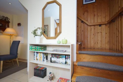 a room with a staircase with a mirror and a book shelf at Pension Vineta Rügen in Baabe