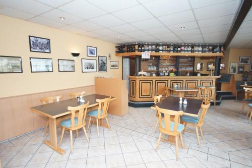 a restaurant with two tables and chairs and a counter at Pension Vineta Rügen in Baabe